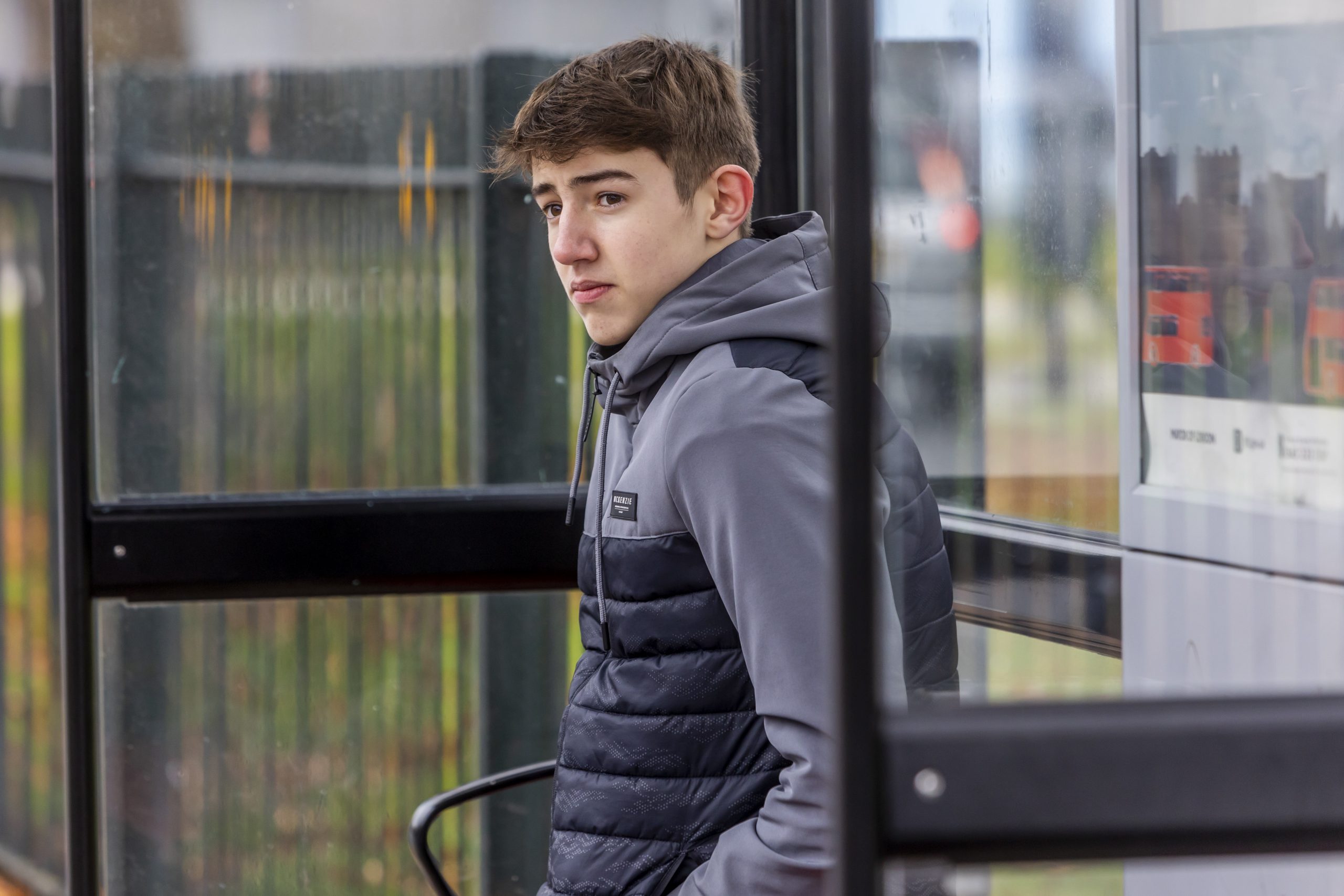 A young person is sitting at a bus stop wondering what happens when your family move away