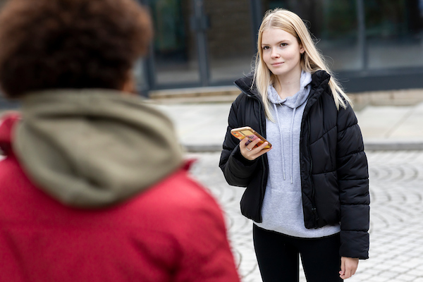 Two young people are standing in the street, talking about finding support for sleep disorders