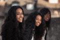 three girls sitting together smiling