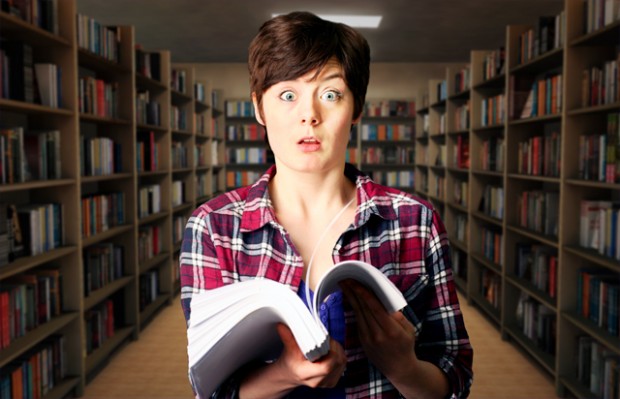Girl with a huge book looking confused.