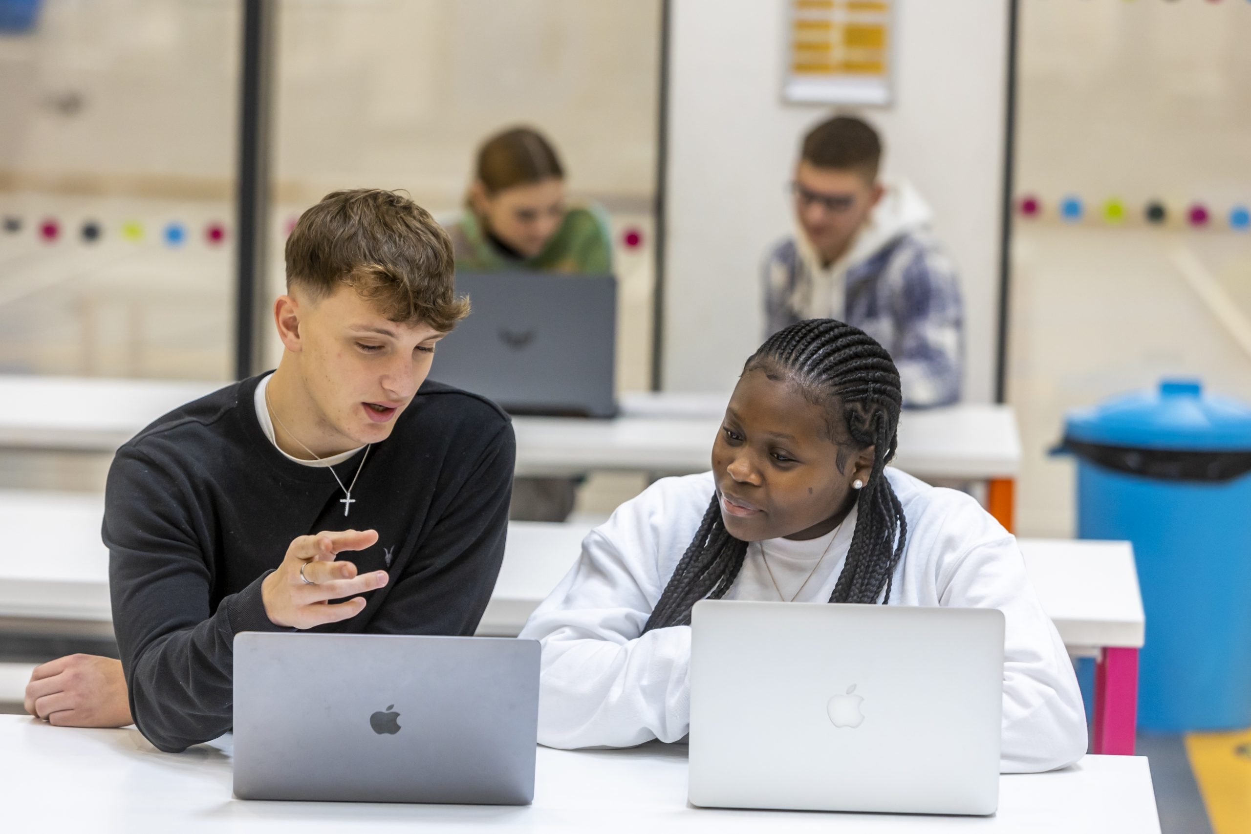 Two young people are on their laptops. They are taking A-levels. This is a wide-angle image.