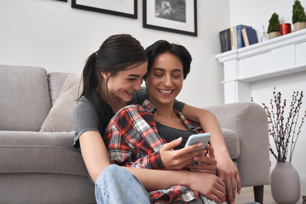 A young couple are sitting on the floor, hugging each other. They are talking about common law marriage. This is a wide-angle image.