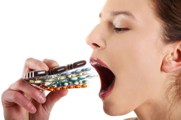 Woman eating lots of types of pill.