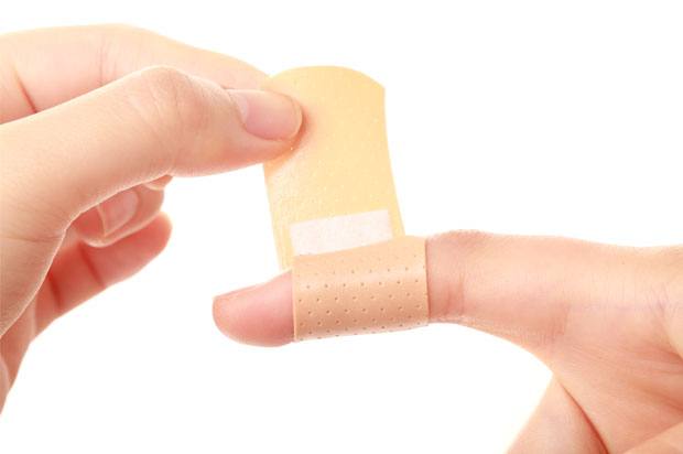 a plaster being put on a finger