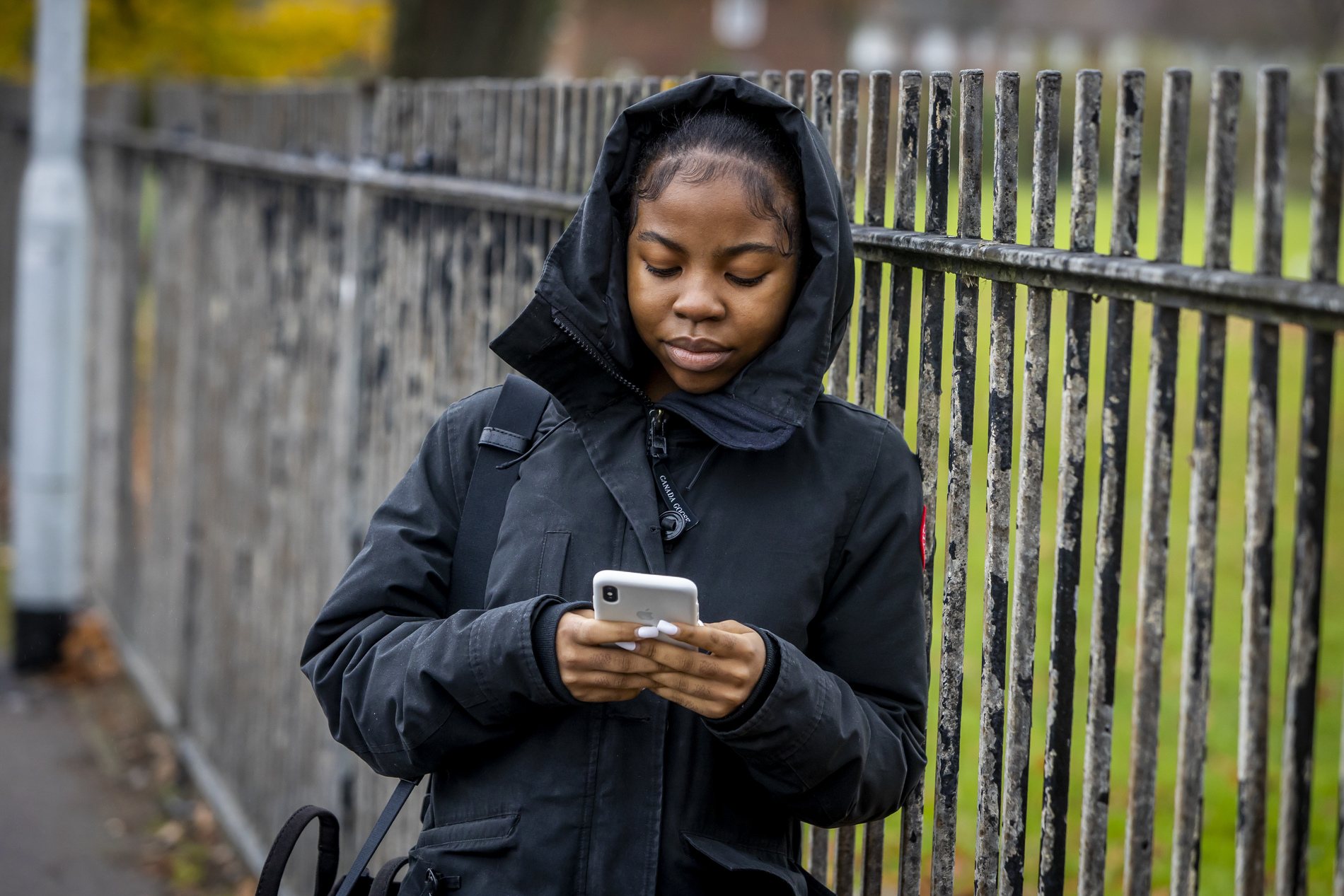 A young woman is on her phone. She is experiencing homesickness. This is a wide-angle image.