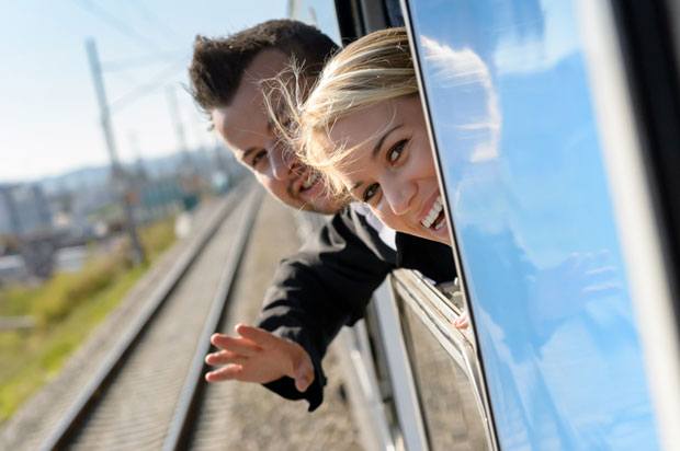 Two young people are looking out of a train window on their InterRailing trip