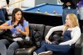 Two young women are sitting on a sofa. They are discussing drug legalisation. This is a wide-angle image.