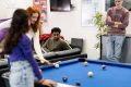 A group of young people are playing pool. They are discussing low sex drives.