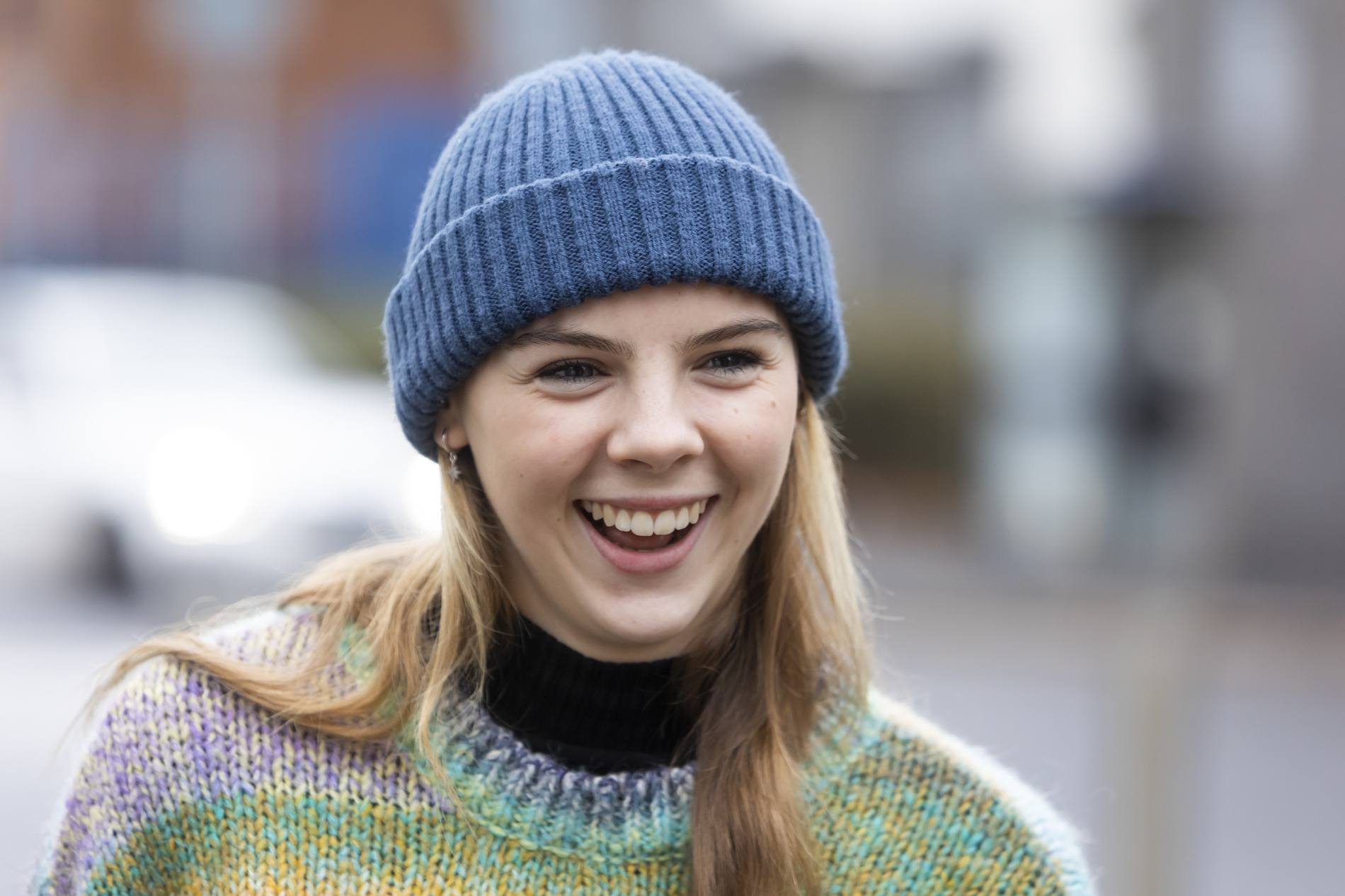 A young woman is smiling. She is thinking about study options for young mums. This is a close-up image.
