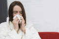 girl in dressing gown sneezing