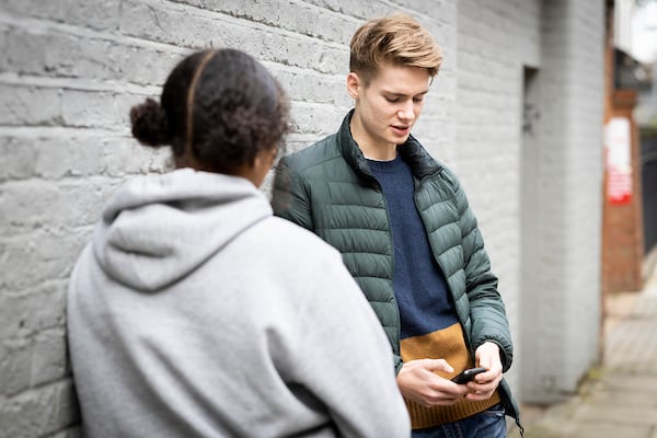 Two young people are standing outside chatting about when is the right time for them.