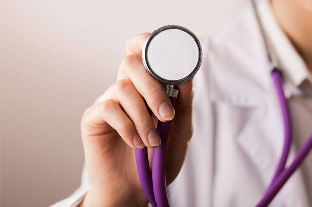 Doctor holding up purple stethoscope