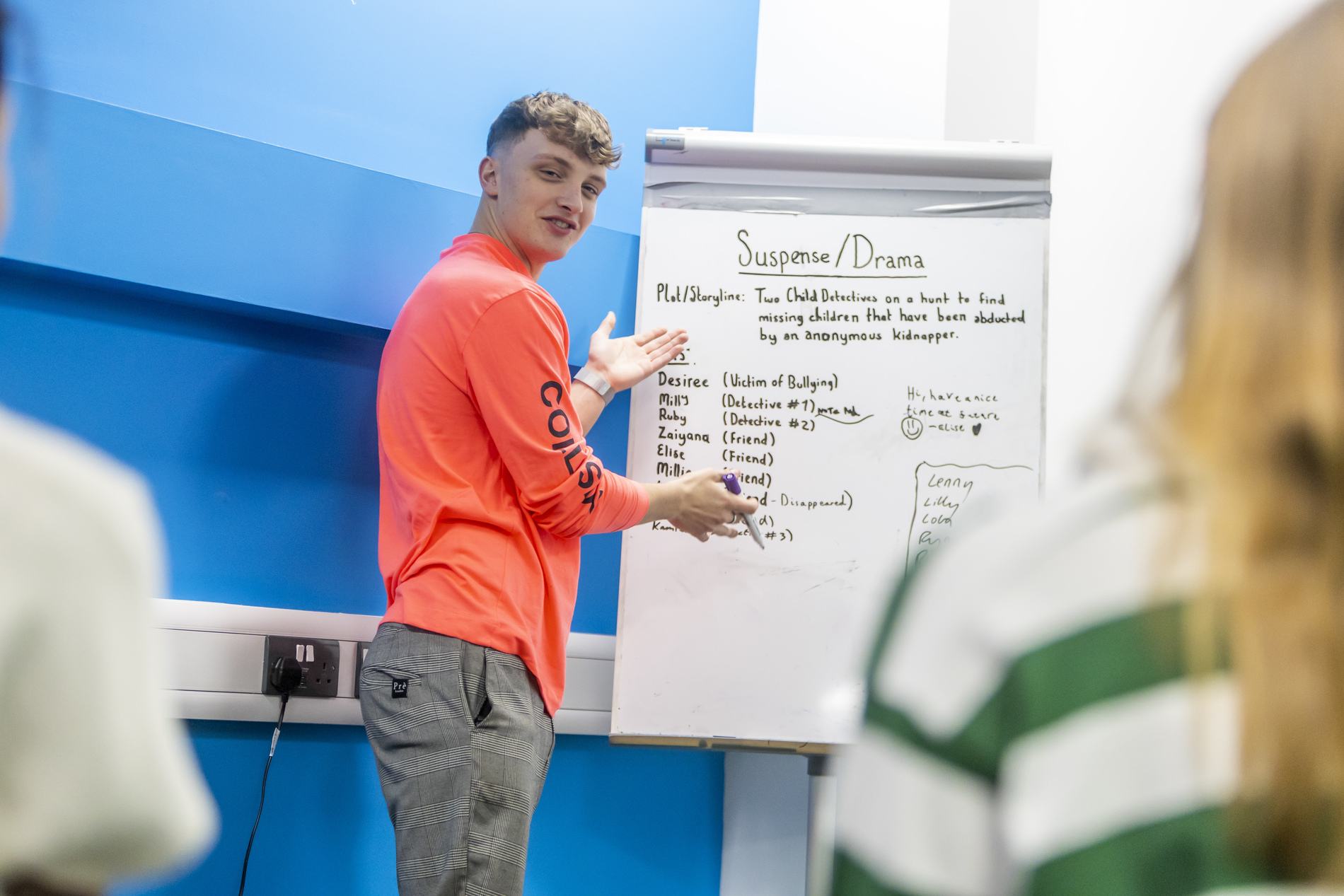 A young man is giving a presentation about apprenticeships. This is a wide-angle image.