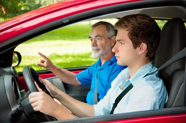 A young men learning to drive with an instructor. drive