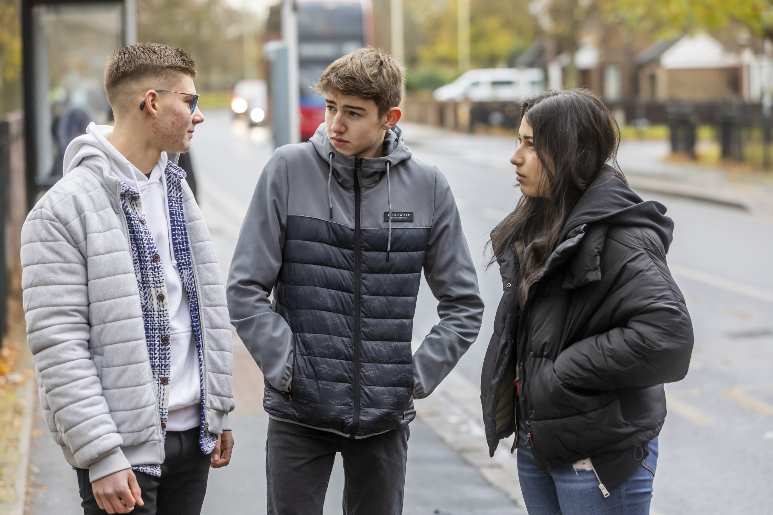 Three young people stand chatting to each other about how police cautions work.