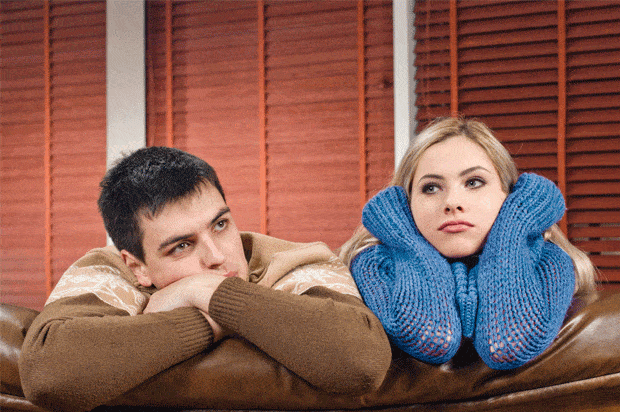 couple looking fed up on the sofa