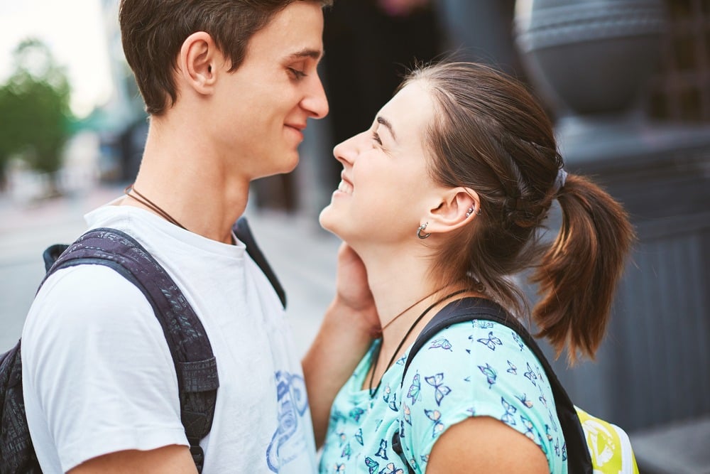 A young couple is staring at each other lovingly. They are discussing drunk sex. This is a close-up image.