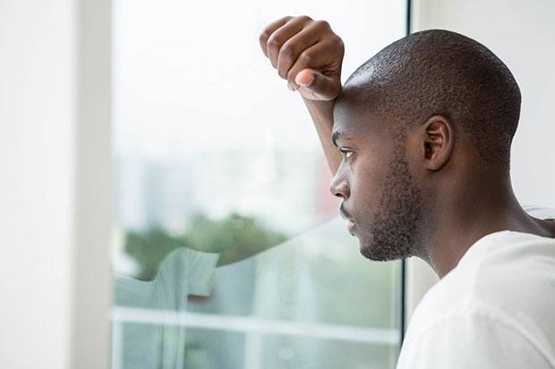 A young person is looking out of the window thinking about hearing voices