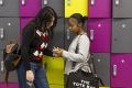 Two friends are standing in the school coridoor talking about how to get treatment for eating disorders