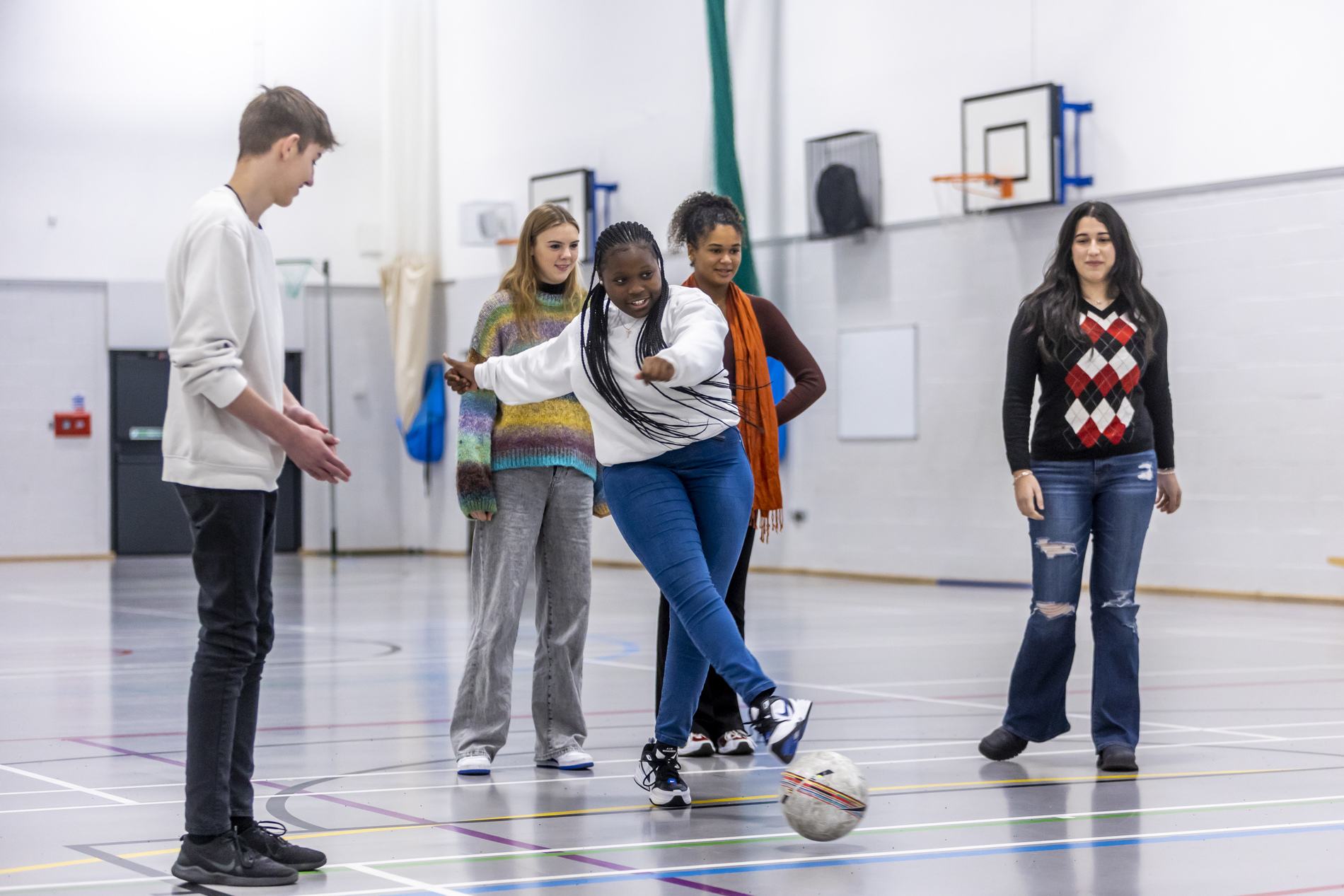 A group of young people are playing games in a gym. Community connection can be crucial for eating disorder support.