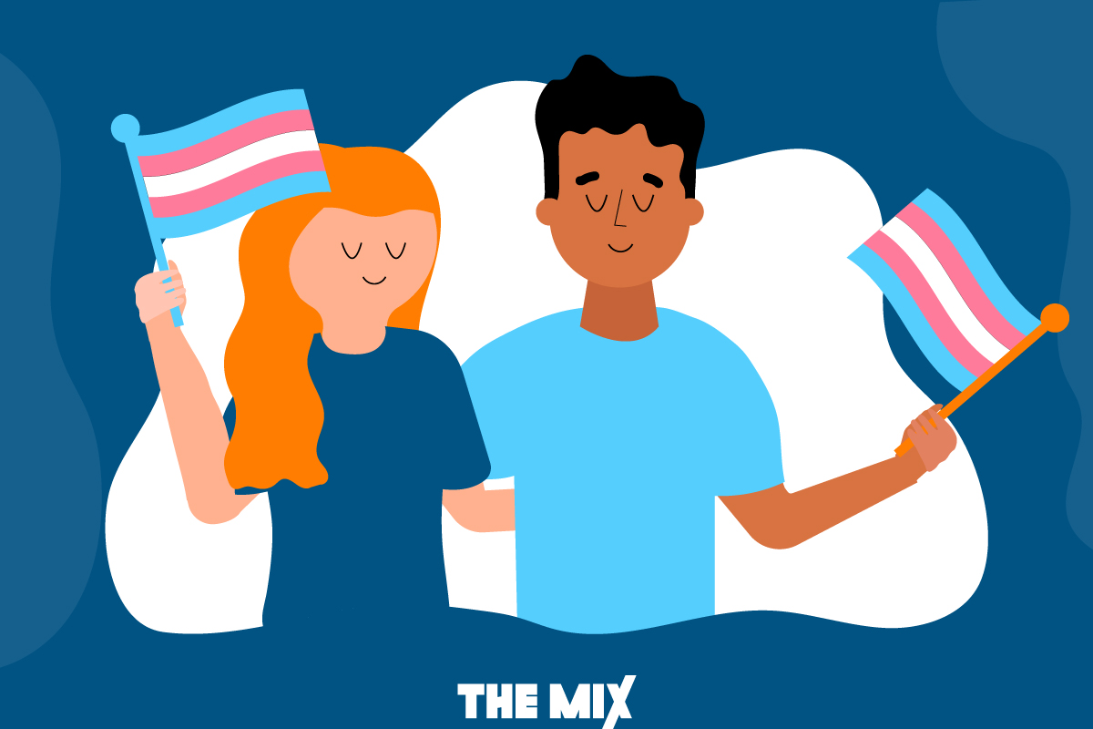 Two young people are standing side by side with their arms around each other. They are waving trans rights flags to support the ban of all conversion practices