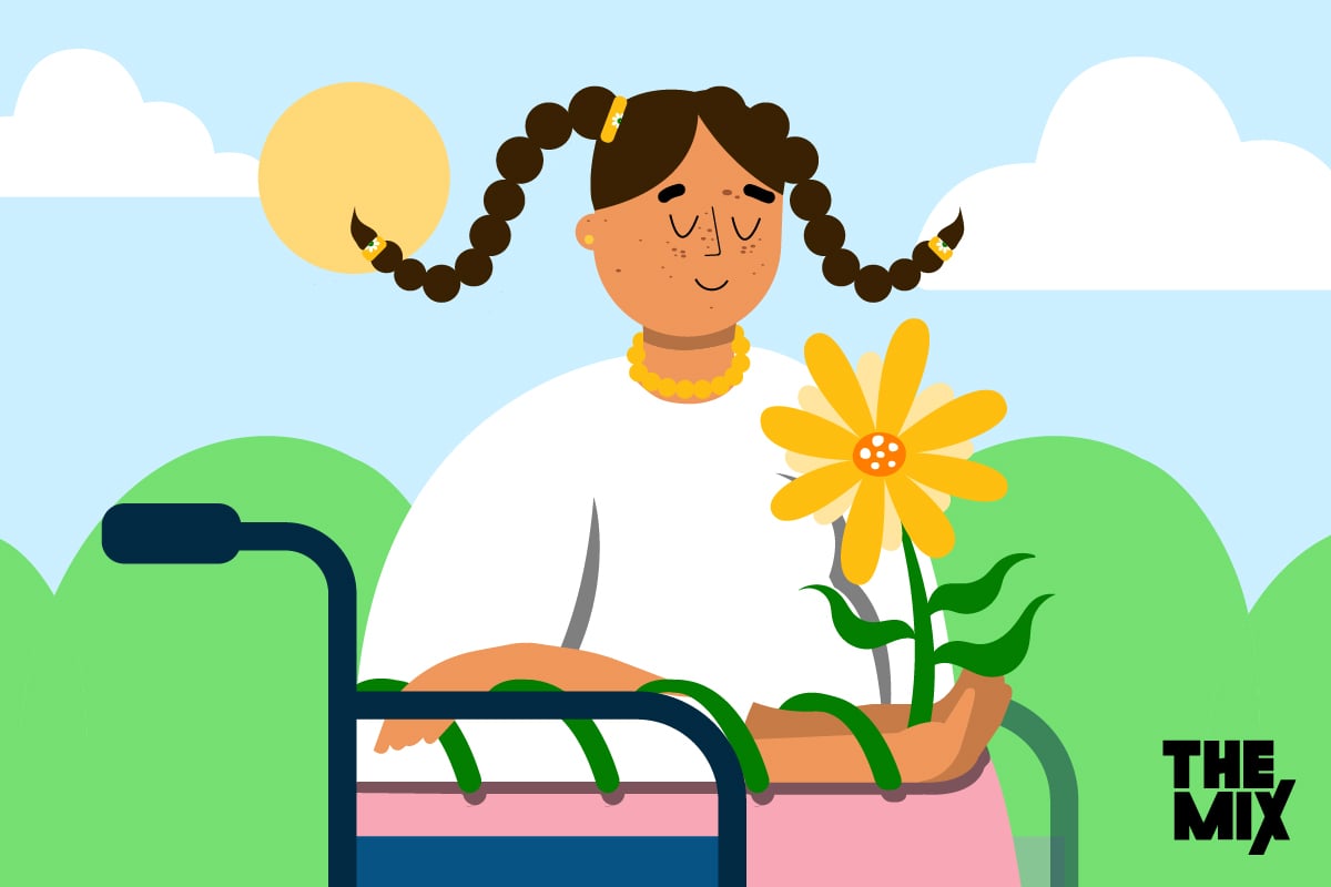 A smiling young women in a wheelchair is out in the sunshine where a bright yellow flower is growing from her arms